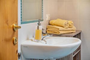 a bathroom with a sink and a mirror and towels at Oberpatiglhof - Anna in Brie