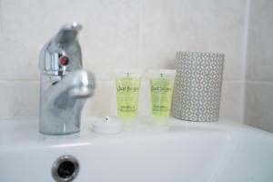 a bathroom sink with two cups and a faucet at Darmeid House in Kirk of Shotts