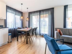 Una sala de estar con una mesa y sillas y un sofá. en Coastal Getaway w Sauna, en Scherpenisse
