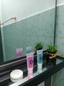 un mostrador de baño con 4 tazas en un espejo en AZ Homestay 1 en Kuantan