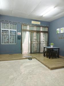 Habitación con mesa, paredes azules, mesa y sillas. en AZ Homestay 1 en Kuantan