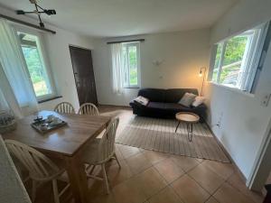 uma sala de estar com uma mesa e um sofá em Verzasca: Casa Sonia em Frasco