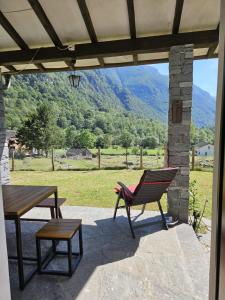 a patio with a table and a bench and a view at Verzasca: Casa Sonia in Frasco