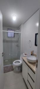 y baño con ducha, aseo y lavamanos. en Apartamento dos ingleses, en Florianópolis