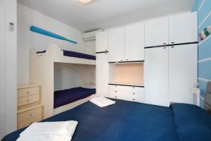 Un dormitorio con una cama azul y armarios blancos. en Beach Paradise - Cicerone, en Levanto