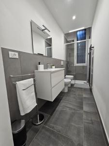 a bathroom with a sink and a toilet and a mirror at A&D apartments in Bologna
