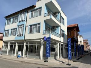a tall building with blue signs in front of it at Maritsa Hotel in Edirne