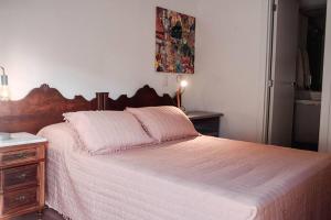 um quarto com uma cama grande com cabeceira de madeira em Apartamento pura vida no Parque Una com vaga de garagem. em Pelotas mais 23 fotografias