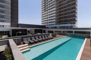 uma piscina no telhado de um prédio em Apartamento pura vida no Parque Una com vaga de garagem. em Pelotas