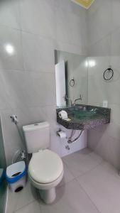 Baño blanco con aseo y lavamanos en Pousada Albuquerque en Jijoca de Jericoacoara