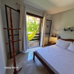 ein Schlafzimmer mit einem Bett und einem großen Fenster in der Unterkunft Casa no Peró - Orla Azul in Cabo Frio