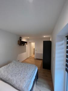 1 dormitorio con 1 cama en una habitación blanca en Moderne 2 Zimmer-Ferienwohnung en Nörten-Hardenberg