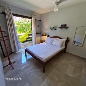 ein Schlafzimmer mit einem Bett und einem großen Fenster in der Unterkunft Casa no Peró - Orla Azul in Cabo Frio