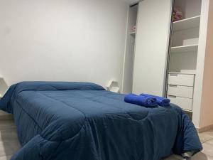 Una cama con una manta azul en un dormitorio en Súpercomodo en Rosario