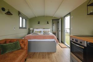 a large bedroom with a bed and a couch at Clover Hut - Snettisham Meadows in Snettisham