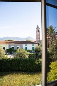 - une vue sur un bâtiment avec une tour d'horloge depuis une fenêtre dans l'établissement [Art of Living] 100 meters from the sea., à Marina di Pietrasanta