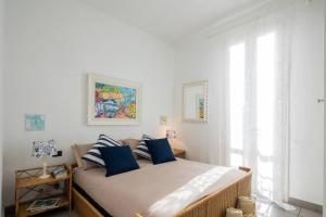 a bedroom with a bed with blue pillows and a window at [Art of Living] 100 meters from the sea. in Marina di Pietrasanta
