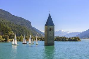 a clock tower in the middle of a lake with sailboats at Ferienwohnung Lamm 3 in San Valentino alla Muta