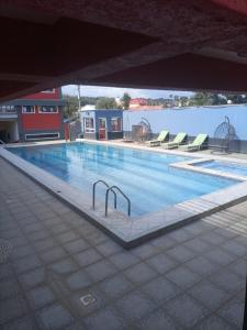 a large swimming pool with chairs in a building at Hotel Good Putt in Nakuru