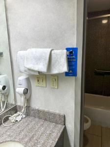 La salle de bains est pourvue d'un lavabo et d'une serviette. dans l'établissement Days Inn & Suites by Wyndham Opelousas, à Opelousas