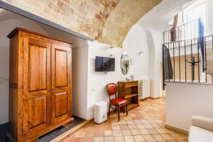uma sala de estar com uma porta de madeira e uma cadeira em L' Abbraccio dei Sassi em Matera