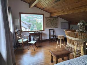 een kamer met stoelen, een tafel en een raam bij Chalet Nicouski in La Salle Les Alpes