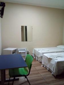 a room with two beds and a table and chairs at Hotel Cidade Aventura in Socorro