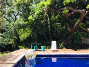 a swimming pool with two chairs and a table and a ball at Bungalito en Cuernavaca in Cuernavaca