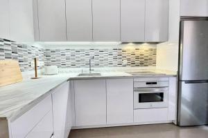 a kitchen with white cabinets and a stainless steel refrigerator at Quartier León VUT-LE-946 in León