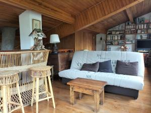 een woonkamer met een witte bank en een tafel bij Chalet Nicouski in La Salle Les Alpes