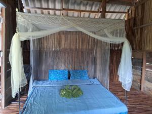 a blue bed with a canopy in a room at Big Hug Home-Nok kao house in Ko Yao Noi