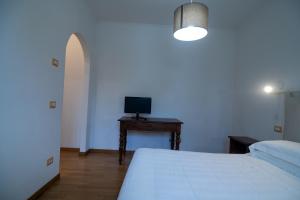 1 dormitorio con 1 cama y mesa con TV en Agriturismo Ai Prati, en Perugia