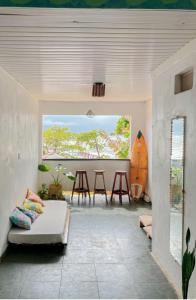 a living room with a couch and a table with a surfboard at LahSelva Pousada Hostel in Itacaré