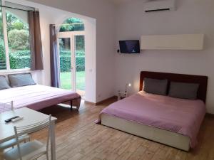 1 Schlafzimmer mit 2 Betten und einem TV an der Wand in der Unterkunft Le Colonne in Stresa