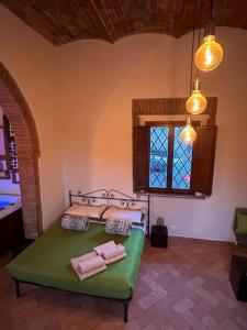 1 dormitorio con 1 cama verde y 2 toallas en Relax nella jacuzzi in Toscana, en Colle Val D'Elsa