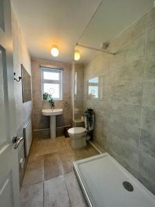 a bathroom with a tub and a toilet and a sink at Bright and Spacious 2-Bed Apartment in Hoddesdon in Hoddesdon