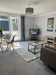 a living room with a couch and a table at Bright and Spacious 2-Bed Apartment in Hoddesdon in Hoddesdon