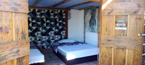niewielka sypialnia z łóżkiem w pokoju z drewnianymi ścianami w obiekcie Casa da Flor Amarela w mieście São Pedro da Aldeia
