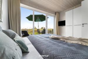 a bedroom with a bed and a large window with an umbrella at Ferienhaus Meerblick Marina Wendtorf in Wendtorf