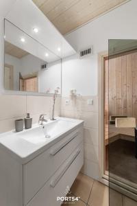 a white bathroom with a sink and a mirror at Ferienhaus Meerblick Marina Wendtorf in Wendtorf +26 photos
