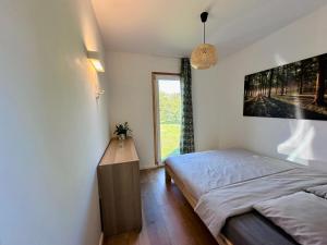 a bedroom with a bed and a large window at Domek letniskowy Ińsko BIO BOX in Ińsko