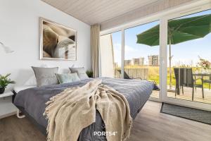 a bedroom with a bed and a large window at Ferienhaus Lagunenblick 40 Marina Wendtorf in Wendtorf