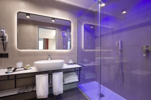 a bathroom with a sink and a glass shower at iQ Hotel Firenze in Florence
