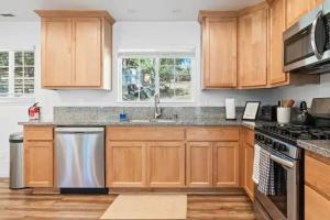 a kitchen with wooden cabinets and stainless steel appliances at Brookside Cottage in Mariposa