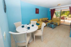 - un salon avec une table, des chaises et un canapé dans l'établissement Apart4mento marav1lloso en la playa De la fossa Paraiso Mar, à Calp