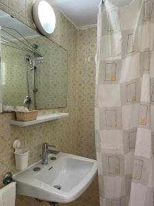 y baño con lavabo y espejo. en Hotel Stiefel, en Lignano Sabbiadoro