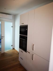 a kitchen with white cabinets and a black oven at Cosy Apartment next to the center of Graz in Graz