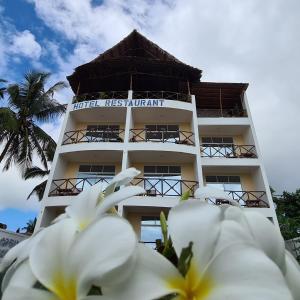 a hotel resort with white flowers in front of it at Villa Vanilla Kendwa in Kendwa