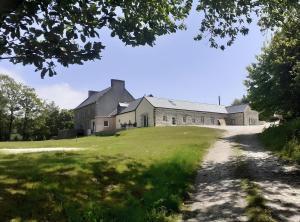 uma antiga casa de campo com um campo de relva em frente em Gite plain-pied - 4 personnes em Landrévarzec