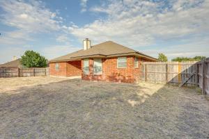 a brick house with a fence in a yard at Lovely Killeen Retreat with Brick Fireplace! in Killeen